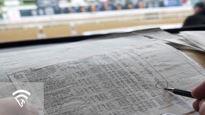 Close up of racing papers related to brisnet speed figure