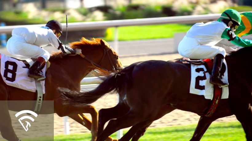 Close up photo of two horses and jockeys very close to each other