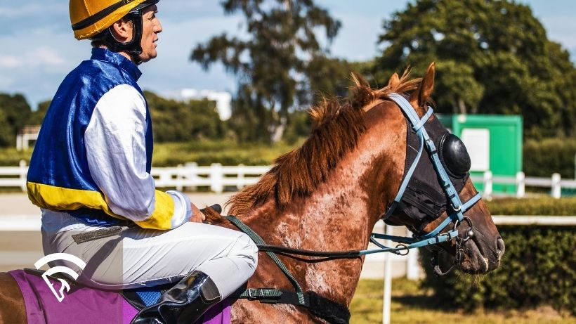 Jockey on a horse representing the topic of the weigh-in and weight-out process for jockeys